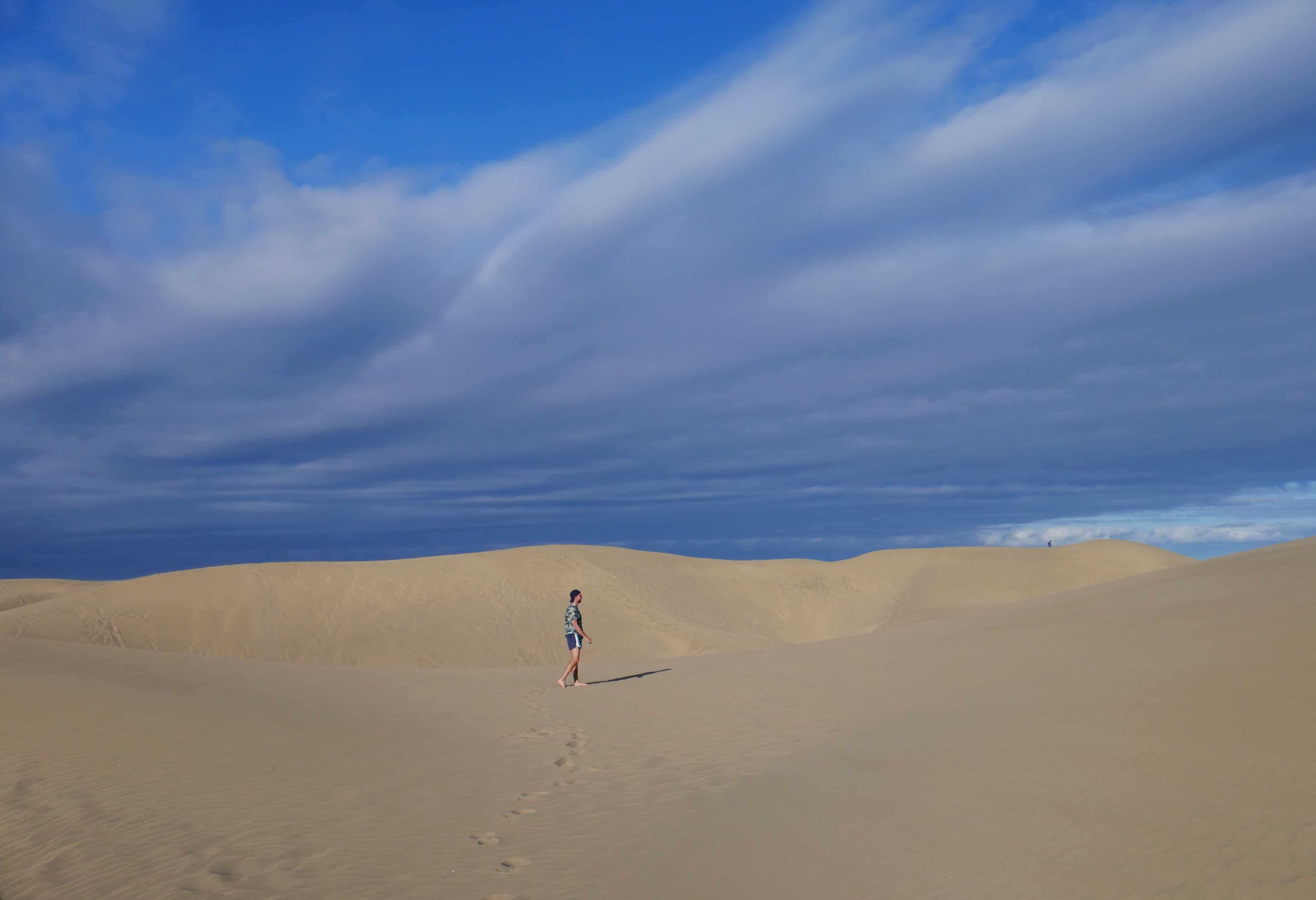 A person walks on the dunes of Maspalomas